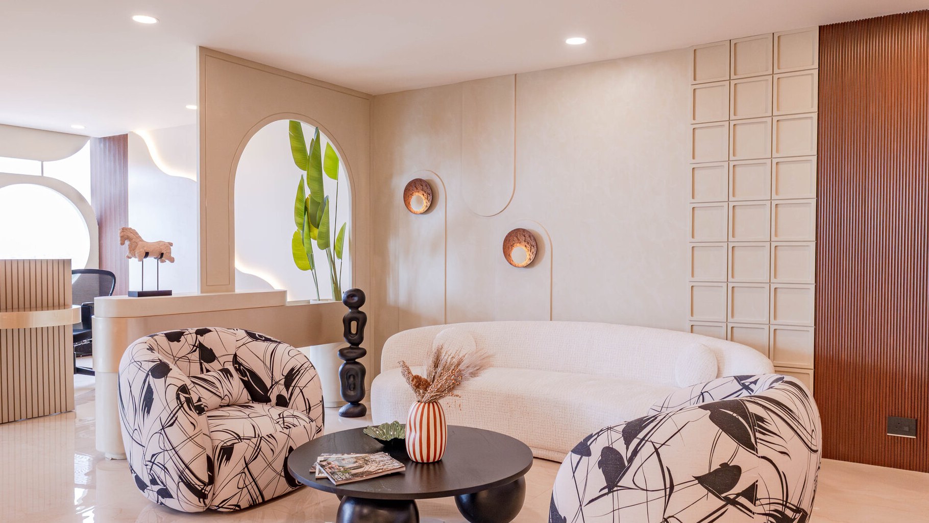 After — finished Beige living room with arched niche, curved sofa and fluted accent wall
