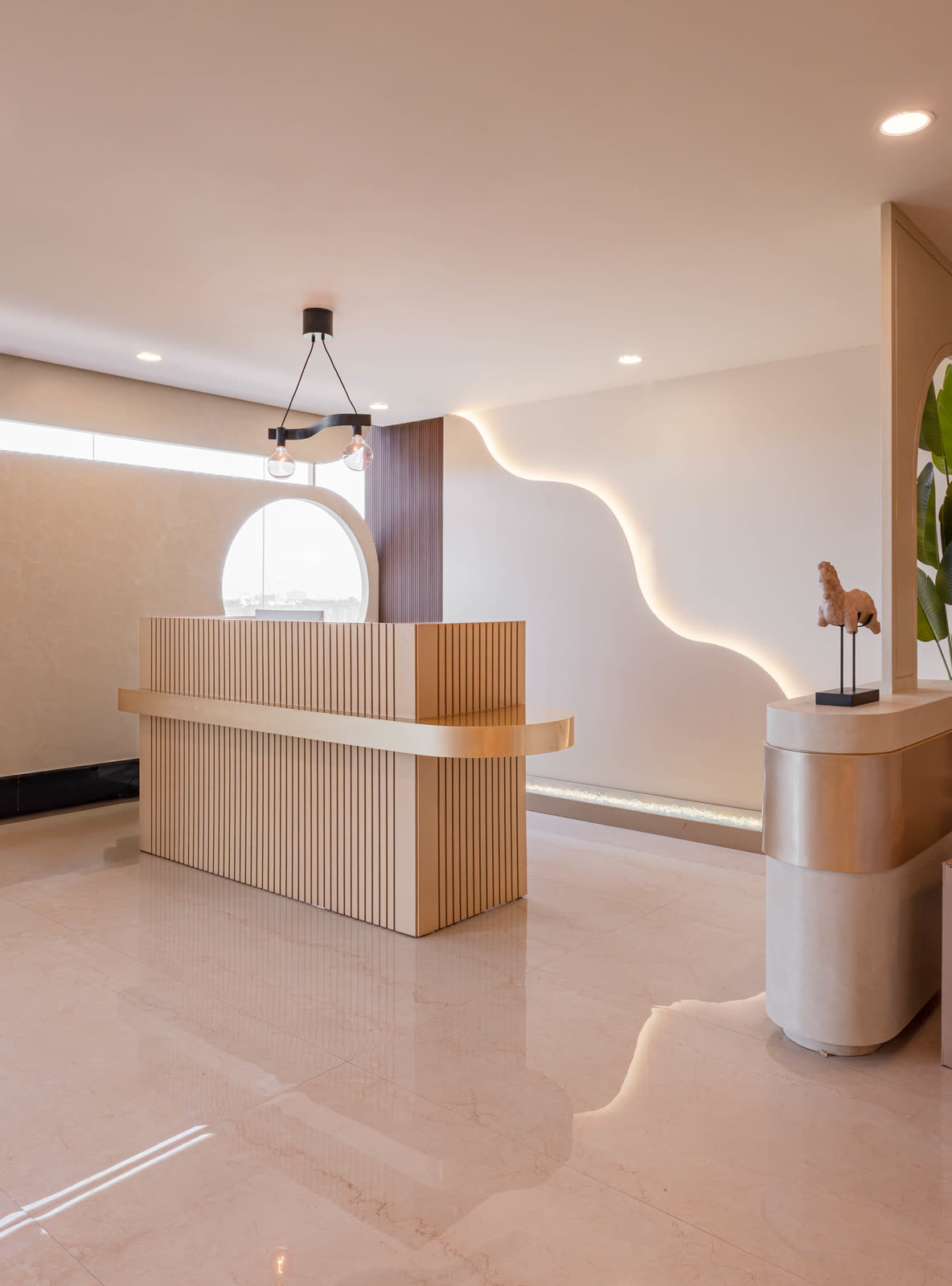 Beige Experience Centre — Foyer & Entry Console — Fluted wood · brass wave light